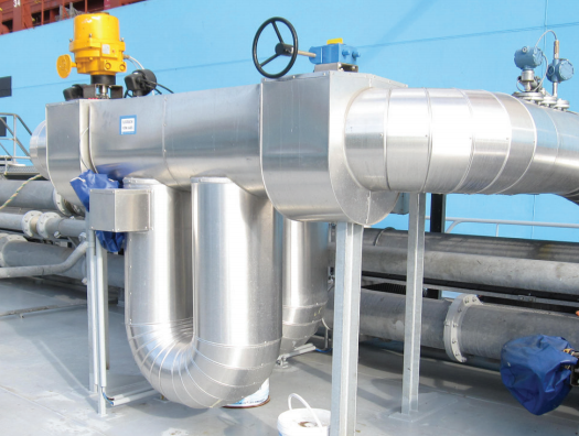 Een metallic pijpsysteem met kleppen en meters, geplaatst op een platform, tegen een blauwe achtergrond.