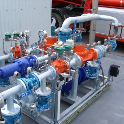Systeem van pijpen en kleppen in een industri&euml;le omgeving, met verschillende kleurige elementen zoals oranje en blauw, gericht op vloeistofbeheer.